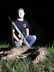 Chris Monhof with two coyotes
